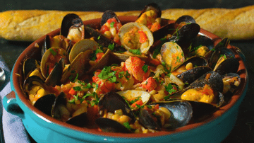 Shellfish-Cassoulet plated in a large ceramic dish.